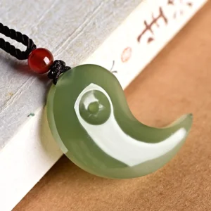 Single dark cyan jade Yin Yang pendant with black cord and red agate bead - side view