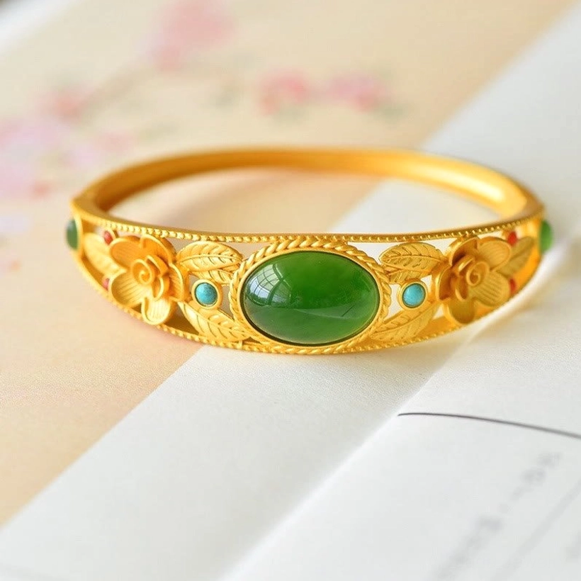 Cyan jade and white jade flower bangle with floral filigree and oval center stone, premium metal setting, top-down view
