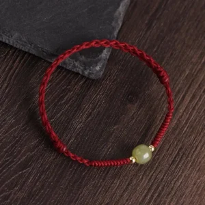 Dark red cord Hetian jade gold spacer beads braided bracelet flat lay