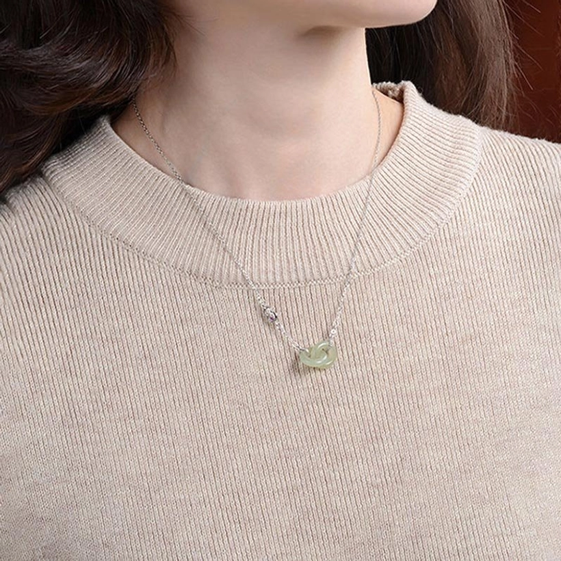 Worn silver jade pendant necklace on neck showing light green double jade hoops casual wear
