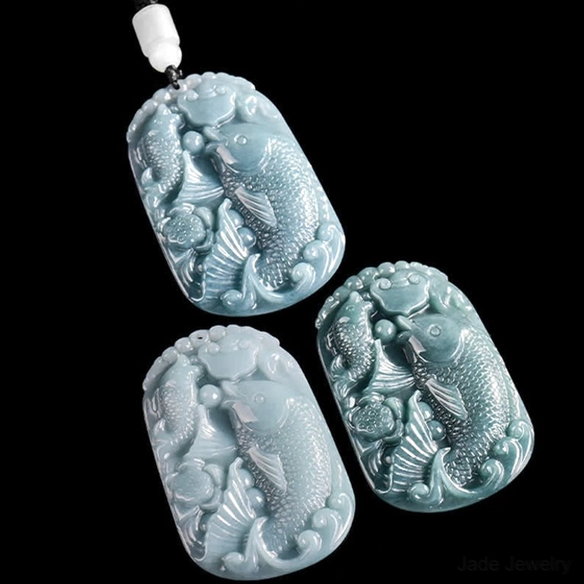 Double koi fish jade pendant close-up detail shot showcasing master artisan hand-carving work, natural jade stone color variation and intricate relief carving craftsmanship