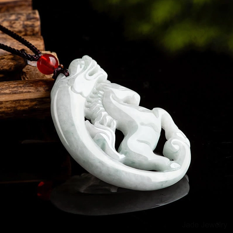 Full side view of polished jade dragon horse pendant on reflective black background showcasing carving depth and detail