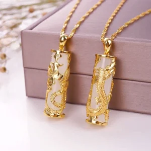 Pair of matching white jade dragon pendants with gold-plated copper chains in coordinated gift box, flat lay overhead view showing fine craftsmanship