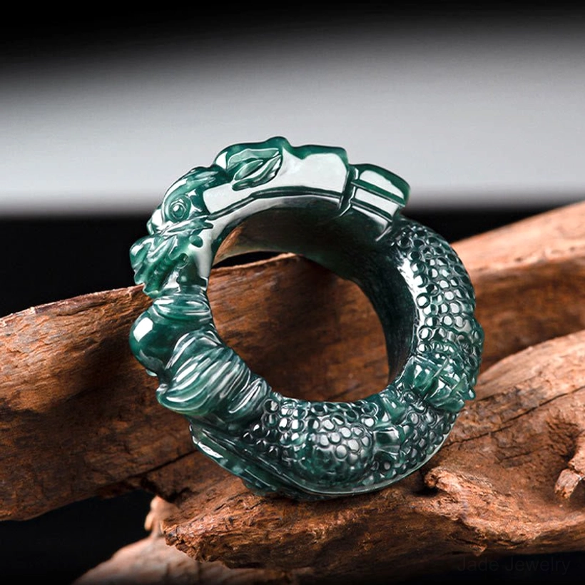 Left side high view of cyan jade dragon ring highlighting prominent dragon head and scaled dragon body texture on polished jade