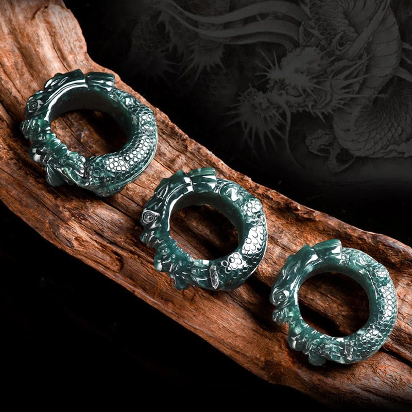 Multiple cyan jade dragon rings in matching dark green displayed in flat lay showing consistent carving quality across different sizes