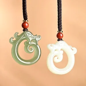 White jade and cyan jade dragon pendants side-by-side comparison hollow carved design with black cord and red bead