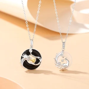 Dragon and Phoenix couple peace buckle necklaces in 925 sterling silver with black onyx and white chalcedony on warm minimalist background, showing matching pair set for couples