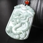 Dragon zodiac jade pendant necklace with hand-carved relief, natural light green jade stone with red auspicious bead and brown hemp cord, celestial talisman