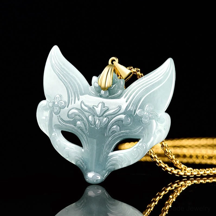 Fox mask jade pendant with floral carvings displayed on draped titanium steel chain against studio black background
