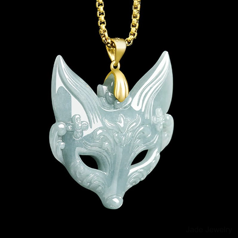 Front view of intricately carved fox mask jade necklace, displaying delicate floral patterns on light cyan jade stone