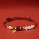 Fu character jade cinnabar red string bracelet with 24K gold plated pendant flat lay front view