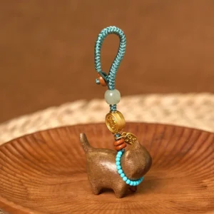Complete sandalwood jade keychain set with decorative beads and blue braided hanging loop on wooden tray