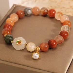 Close-up side view of Fu Lu Shou jade bracelet featuring flower charm, pearl accent, and mixed crystal beads in warm earth tones