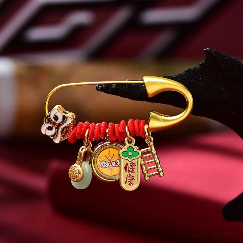 Gold finish dancing lion jade brooch close-up with health character charm and natural jade pendant