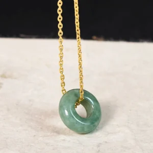 Gold plated jade peace buckle necklace close-up frontal view - premium natural green jade donut pendant with delicate cable chain