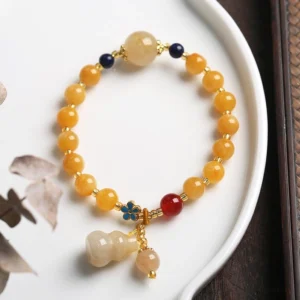 Yellow Jade Gourd Charm Bracelet with Enamel Flower and Red Accent Bead - Flat Lay Detail