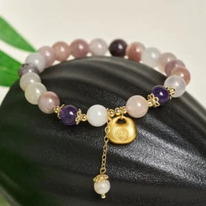 Close-up of golden silk jade blessing bracelet with engraved Fu pendant, stone beads with natural gradient, professional jewelry photography