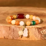 Golden Silk Jade Gourd Charm Bracelet with Red Agate Beads - Overhead Flat Lay View