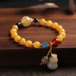 Golden Silk Jade Gourd Wealth Bracelet - Top Down View with Dual Pendants and Enamel Flower Charm