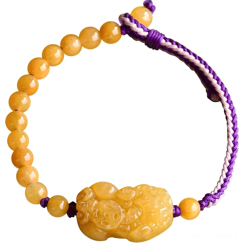 Golden Silk Jade Pi Xiu bracelet close-up featuring purple braided cord and carved wealth charm