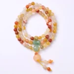 Golden silk jade pumpkin triple wrap bracelet flat lay top view with warm gradient beads and pumpkin charm on white background