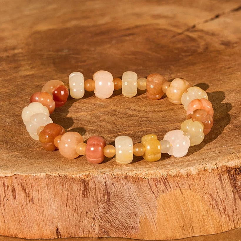 Golden Silk Jade pumpkin bead bracelet flat lay top view on wooden surface showing warm honey and amber barrel beads