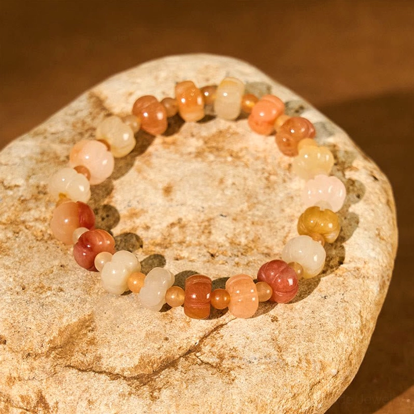 Golden Silk Jade pumpkin beaded bracelet flat display on natural stone with gradient warm color bead arrangement