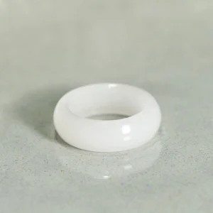 Natural golden silk jade ring flat lay top-down view on gray countertop displaying glossy finish and pure jade tone