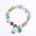 Gourd jade bracelet with pastel pink crystal and citrine beads, top-down flat lay view showing complete design
