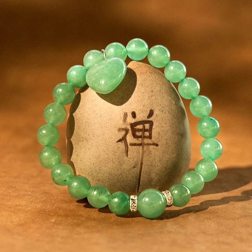 Green Aventurine heart charm bracelet displayed on zen stone with Chan character