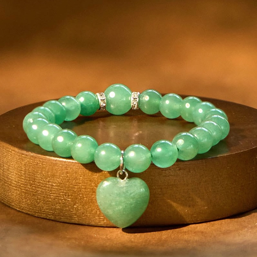 Green Aventurine heart bracelet with polished beads and rhinestone metal spacers on wooden base