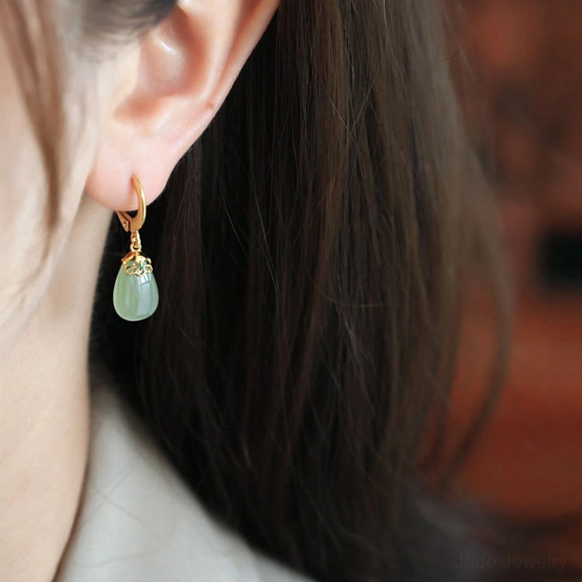Green chalcedony water drop earrings detail showing smooth polished finish pale green hue light reflecting gemstone