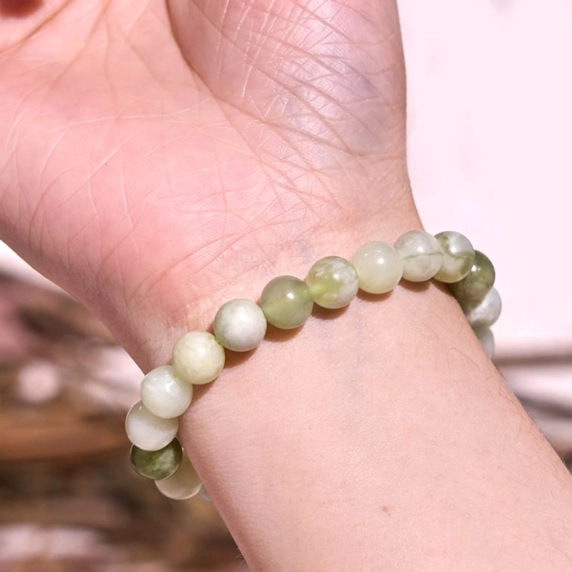 Green harmony jade bracelet detail, close-up of polished gemstone beads showing natural color gradation and craftsmanship