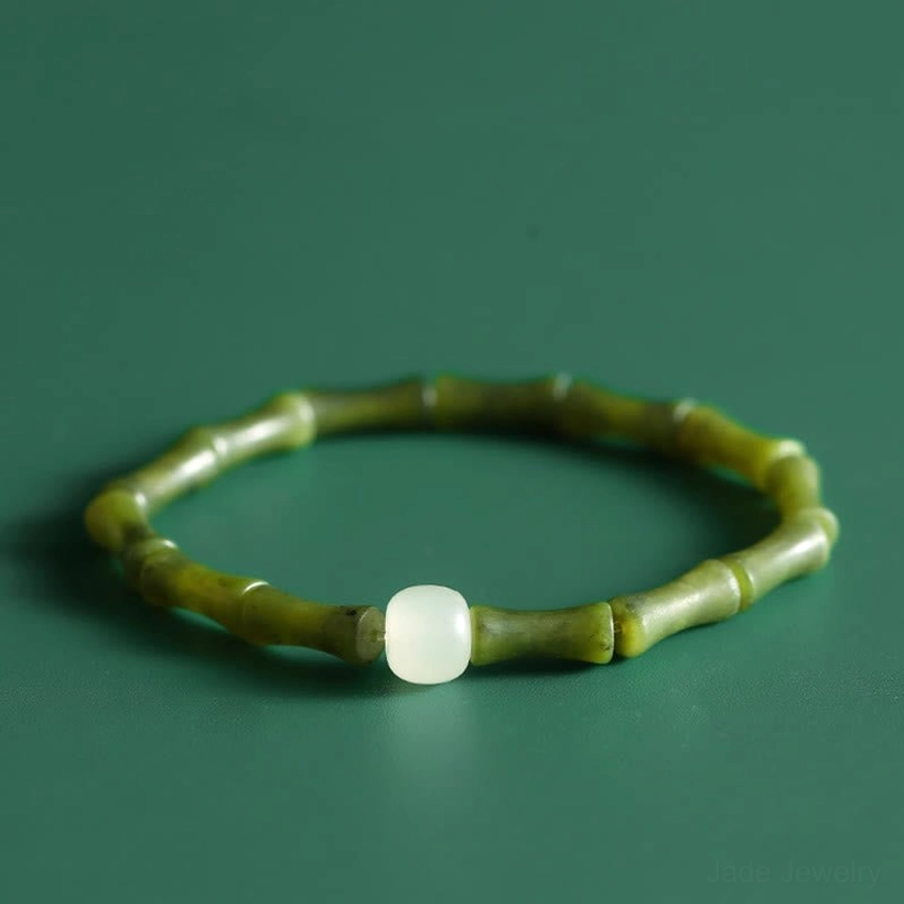 Overhead view of green bamboo jade bracelet with elastic string on dark background, showing full circular design