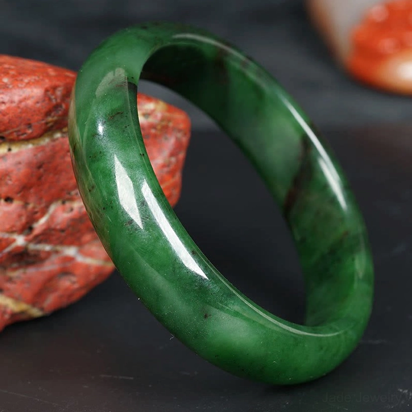 Green jade bangle bracelet polished glossy surface dark mineral patterns