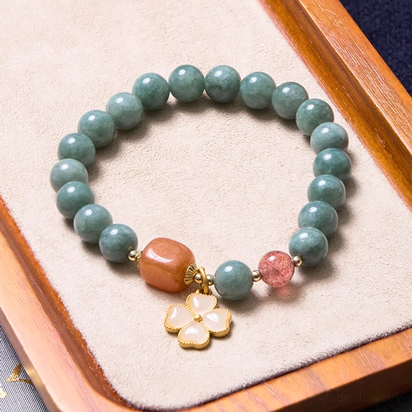 Oil-green jade beaded bracelet with strawberry quartz and gold four-leaf pendant close-up detail