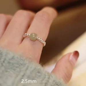 Light green hetian jade beaded elastic ring with 2.5mm sterling silver spacer beads worn on finger close-up
