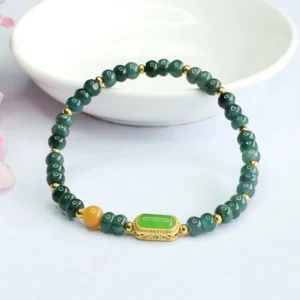 Complete circular green jade luck bracelet displayed on white ceramic dish, showing full bead design
