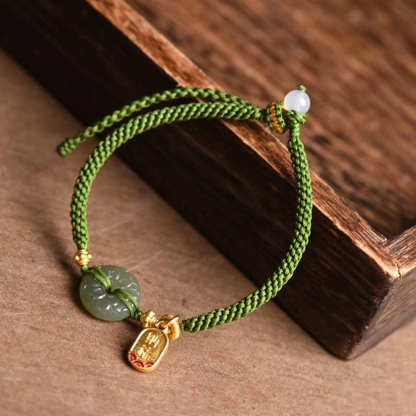 Green braided cord jade bracelet with white accent bead and gold charm detail
