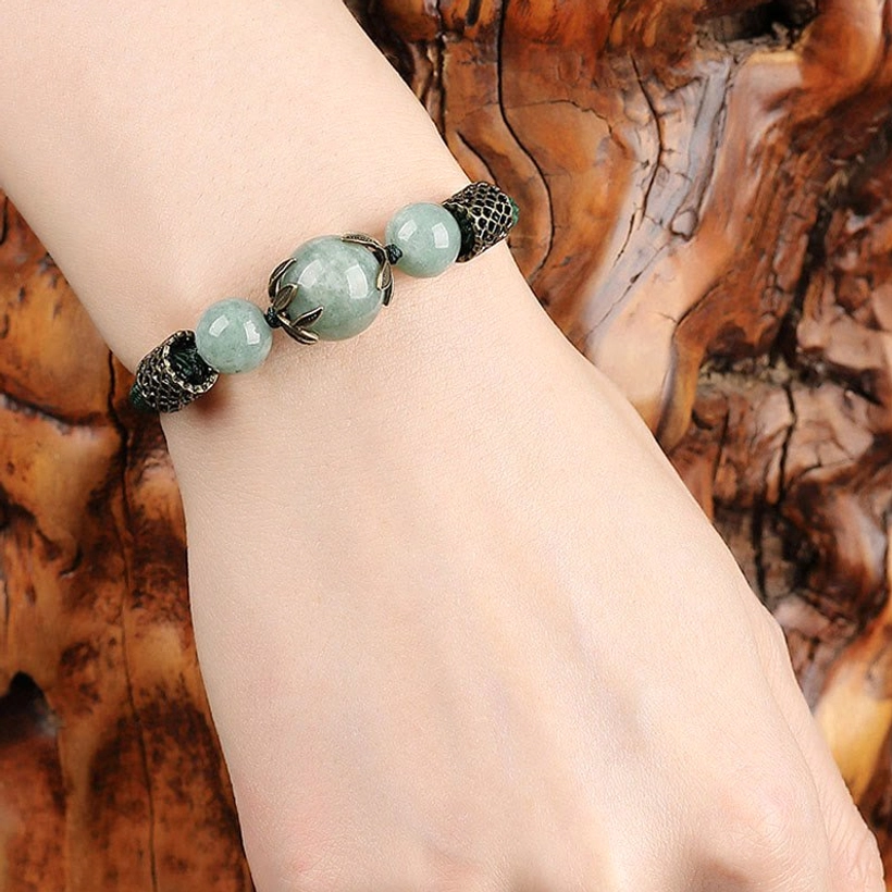 Close-up of green jade prosperity bracelet worn on woman's slim wrist showing compact vintage design