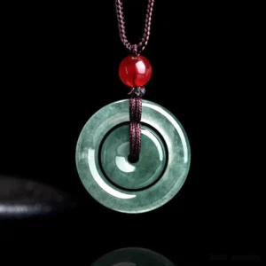 Green jade double peace buckle pendant necklace front view with dark forest green jade, braided brown cord, and red glass accent bead on black background