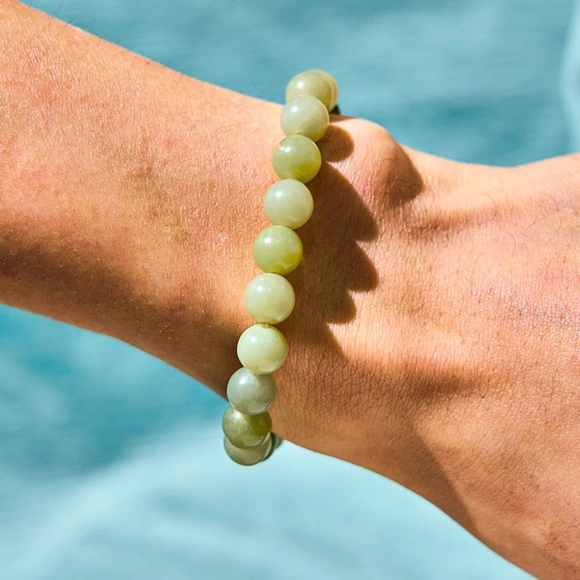 Jade Fu character bracelet side view showing gradient green beads and minimalist design on wrist