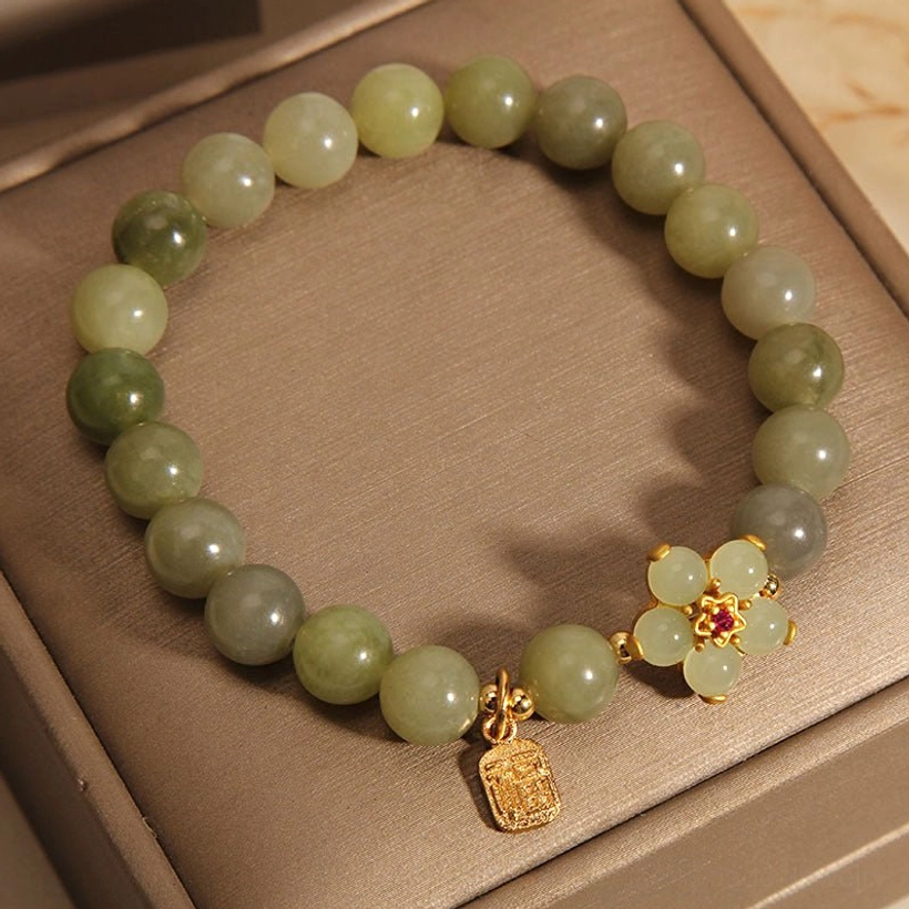 Jade beaded bracelet with elastic band closure showing comfort fit and feng shui prosperity meaning on luxury background