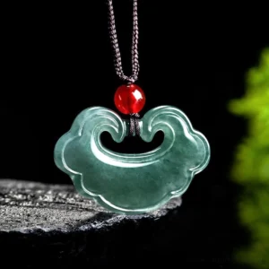 Natural green jade lock pendant necklace close-up front view showing smooth glossy finish and carved lock design with red bead on brown cord