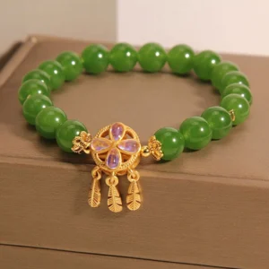 Genuine green jade beads with gold dreamcatcher pendant and iridescent four leaf clover charm - front angle