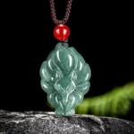 Natural green jade nine-tailed fox pendant necklace with brown braided cord and red bead, front flat view