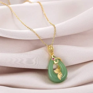Green jade oval pendant necklace with gold chain, gold leaf ornament and red gemstone accent on pink satin - handmade prosperity charm