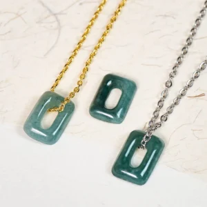 Matching green jade square pendant necklaces with gold and silver chains, flat lay overhead view on textured background