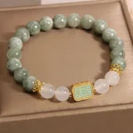 Green jade white agate Hah Taew five lines prosperity bracelet in gold gift box - top view flat lay