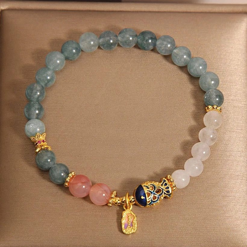 Handmade jade koi fish bracelet overhead flat lay in gift box with mixed stone beads and charm